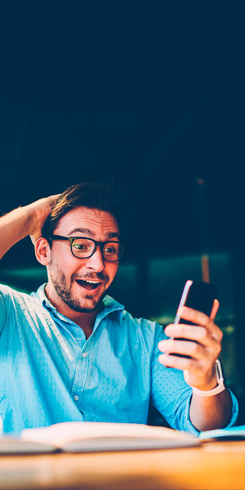 Nadšený muž s telefonem v ruce – ilustrační foto ke službě CSS partner