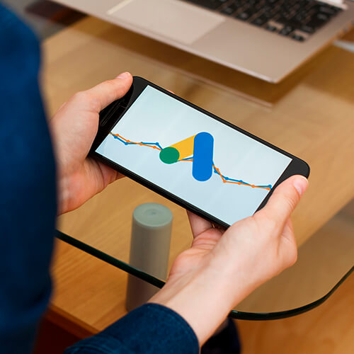 Graf výkonu kampaně zobrazený na telefonu v rukou uživatele
